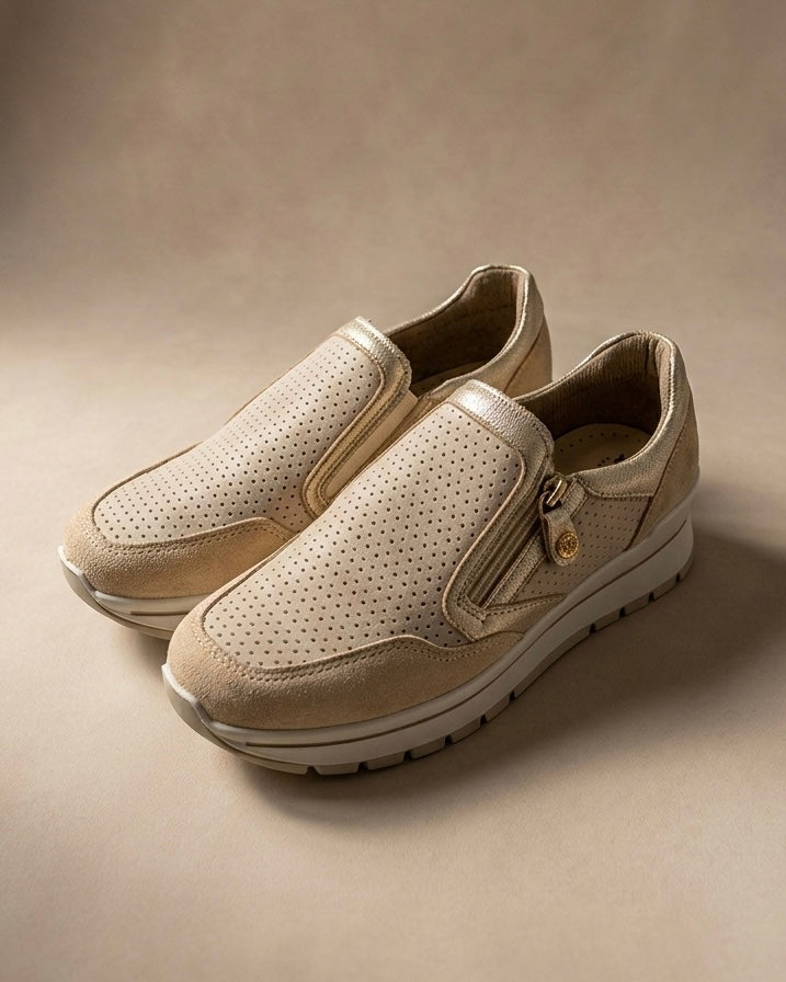 Sneakers da donna marca iMac in camoscio beige con tomaia traforata al laser, profili laminati oro, zip laterale decorativa e suola sportiva bianca.
