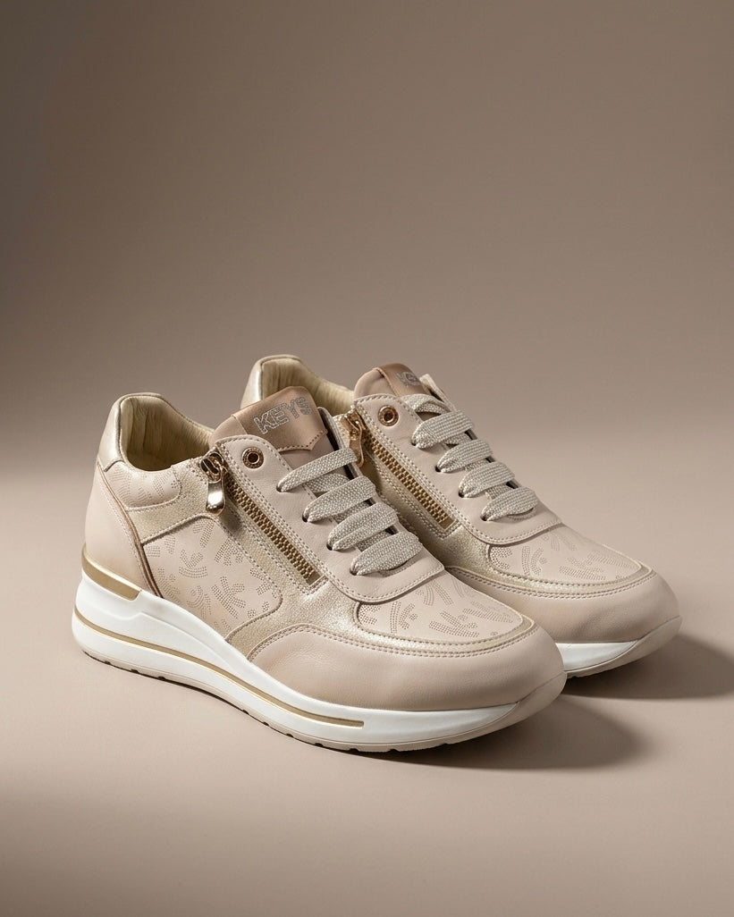 Sneakers Keys da donna color beige champagne con stampa monogram all-over, dettagli laminati oro, doppia zip laterale e suola chunky bianca.