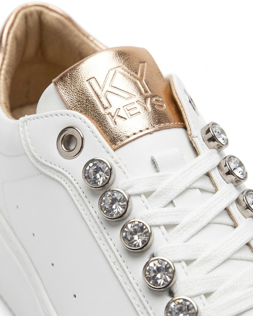 Sneakers donna bianche brand KEYS con grandi castoni gioiello sui lacci, linguetta e tallone oro rose lucido, suola platform panna-dettaglio.