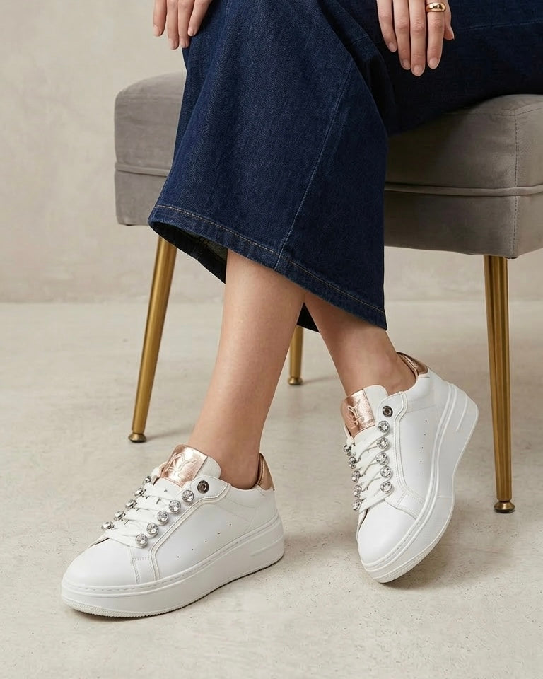 Sneakers donna bianche brand KEYS con grandi castoni gioiello sui lacci, linguetta e tallone oro rose lucido, suola platform panna-modella.