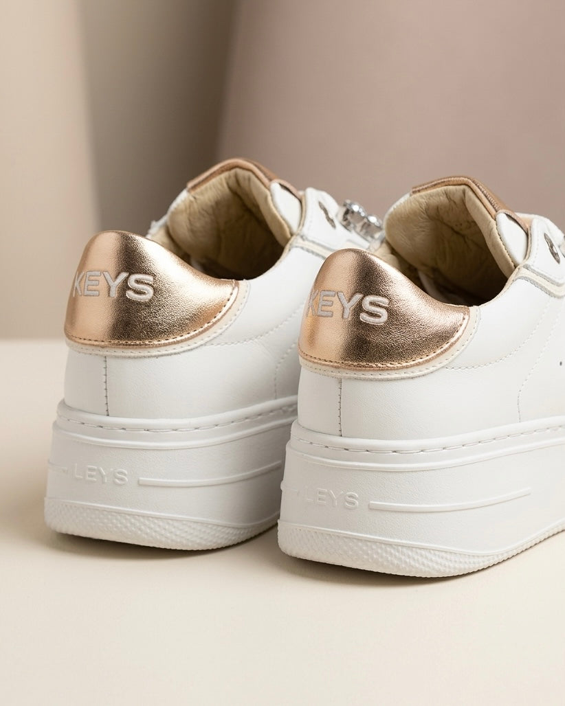 Sneakers donna bianche brand KEYS con grandi castoni gioiello sui lacci, linguetta e tallone oro rose lucido, suola platform panna-retro.