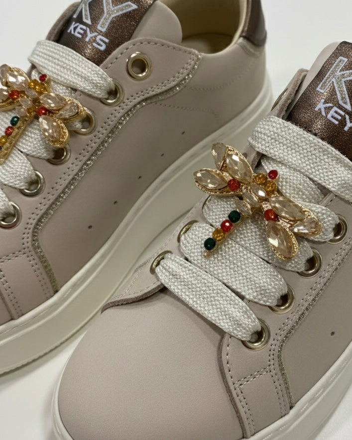 Sneakers platform Keys donna color cipria con dettagli bronzo e farfalla gioiello sui lacci - dettaglio ravvicinato.