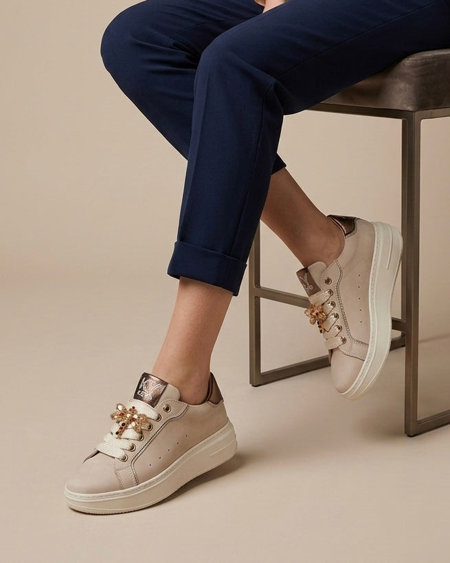 Sneakers platform Keys donna color cipria con dettagli bronzo e farfalla gioiello sui lacci - indossato modella.