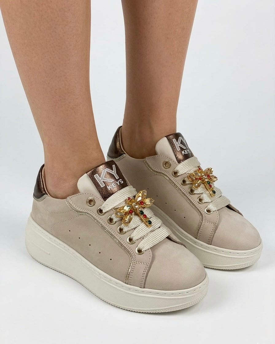 Sneakers platform Keys donna color cipria con dettagli bronzo e farfalla gioiello sui lacci - indossate.