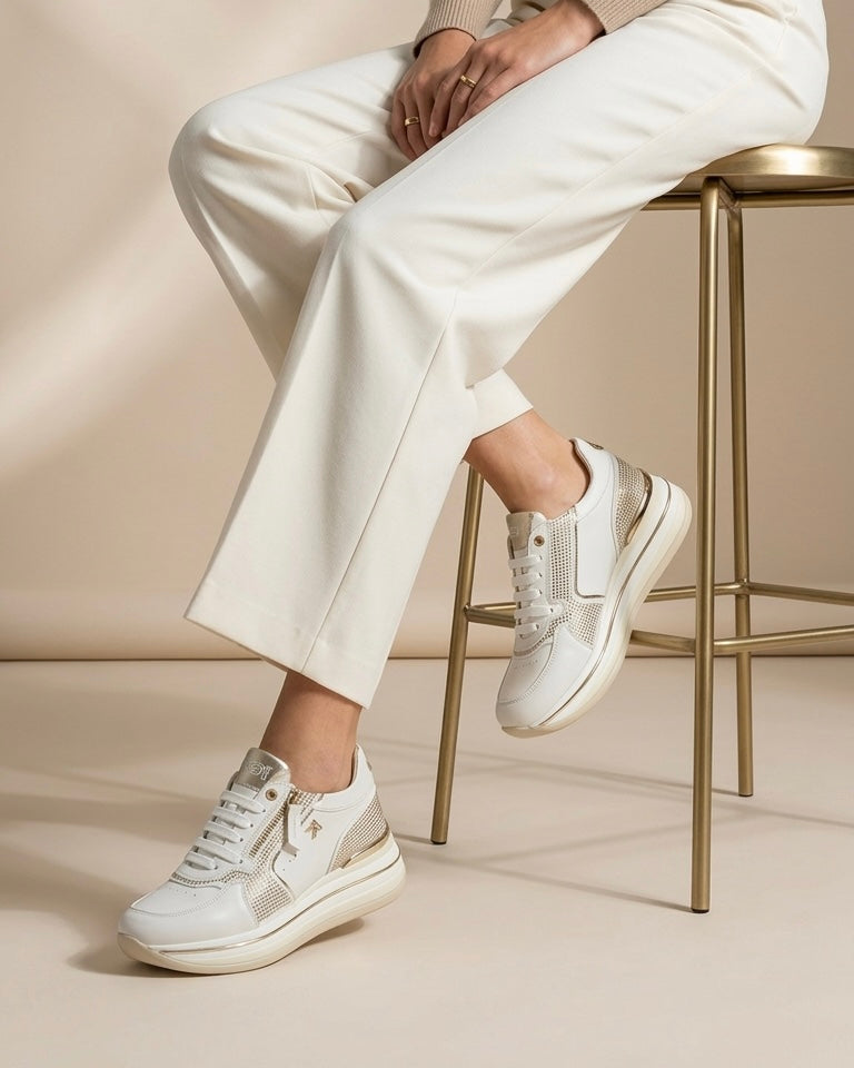 Sneakers Keys da donna in pelle bianca con inserti laterali in strass dorati, suola platform e chiusura con zip e lacci - indossate modella.