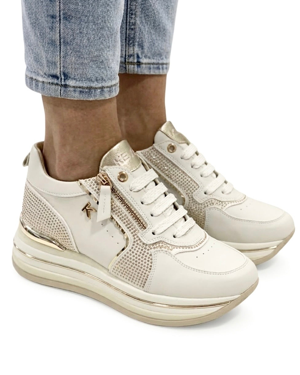 Sneakers Keys da donna in pelle bianca con inserti laterali in strass dorati, suola platform e chiusura con zip e lacci - indossate.