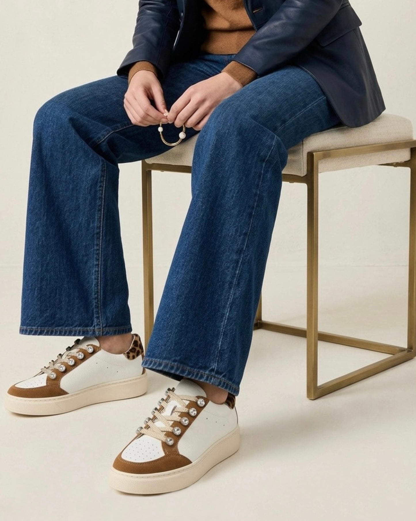 Sneakers bianche e marroni in pelle Divine Follie con dettagli gioiello sui lacci e inserto animalier leopardato sul tallone-modella.