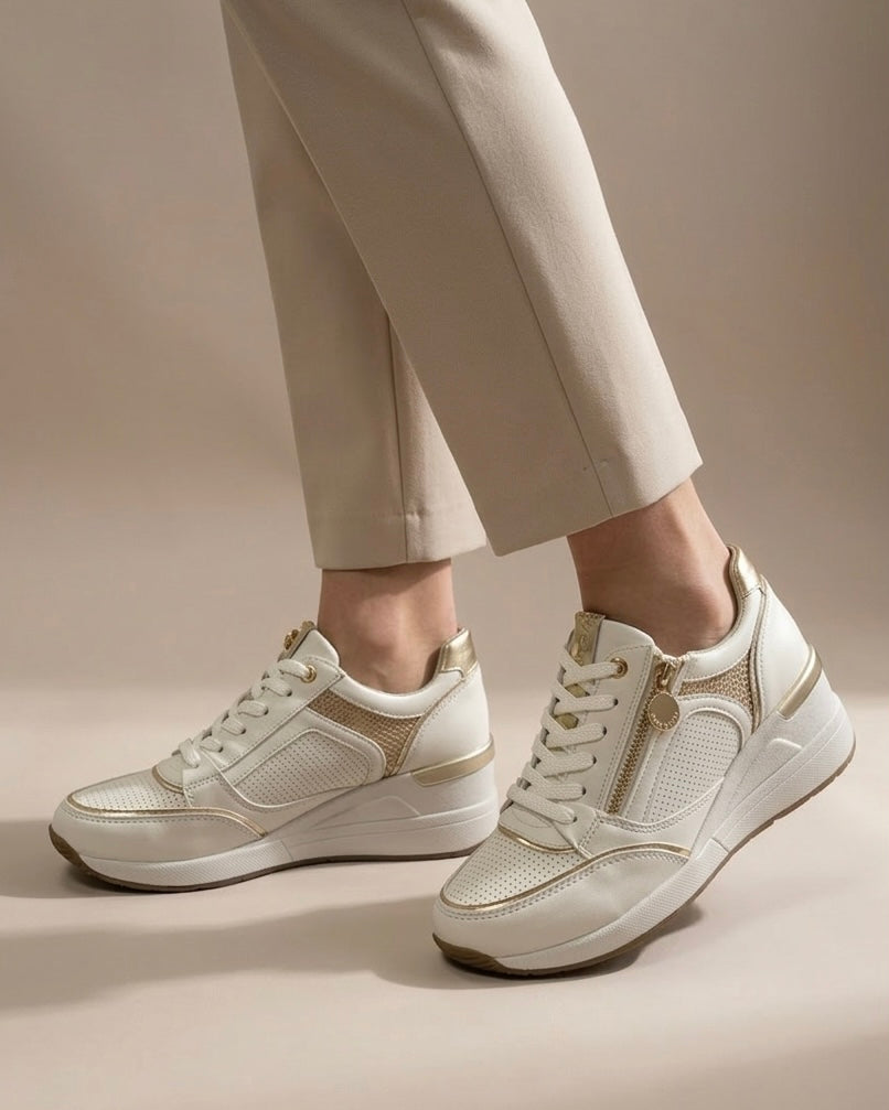 Sneakers Stonefly da donna in pelle bianca traforata con eleganti finiture oro, zeppa ammortizzata e zip laterale-indossate.