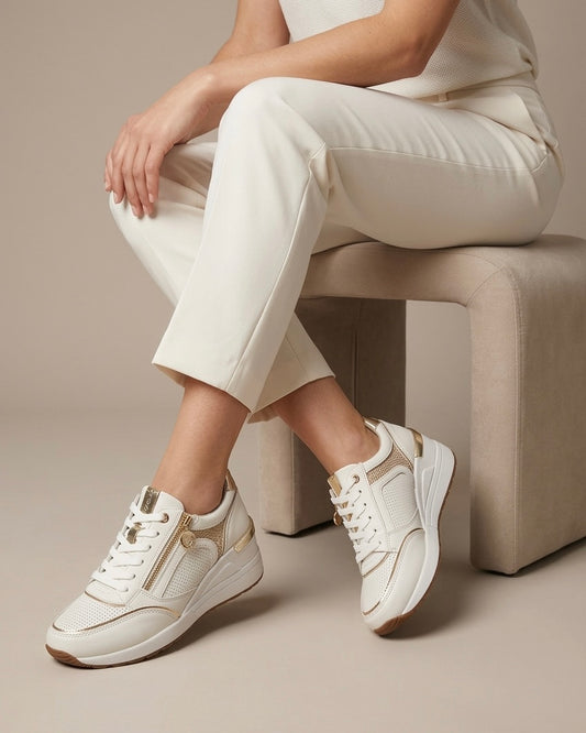 Sneakers Stonefly da donna in pelle bianca traforata con eleganti finiture oro, zeppa ammortizzata e zip laterale-modella.