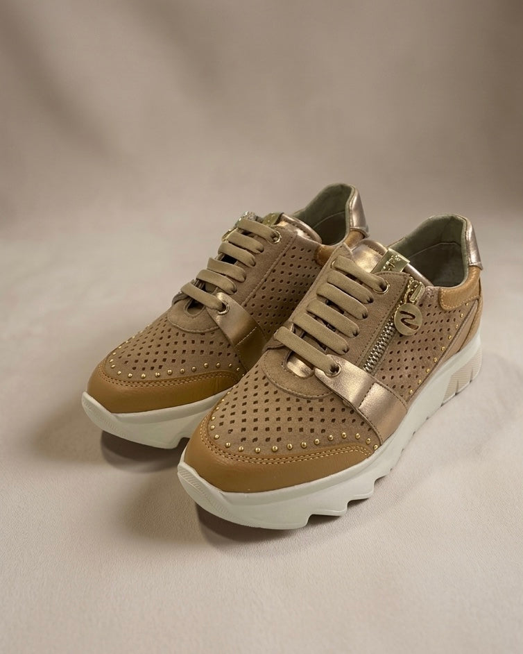 Sneakers Stonefly da donna color sabbia con pelle traforata, dettagli laminati oro, suola bianca sagomata e pratica zip laterale.