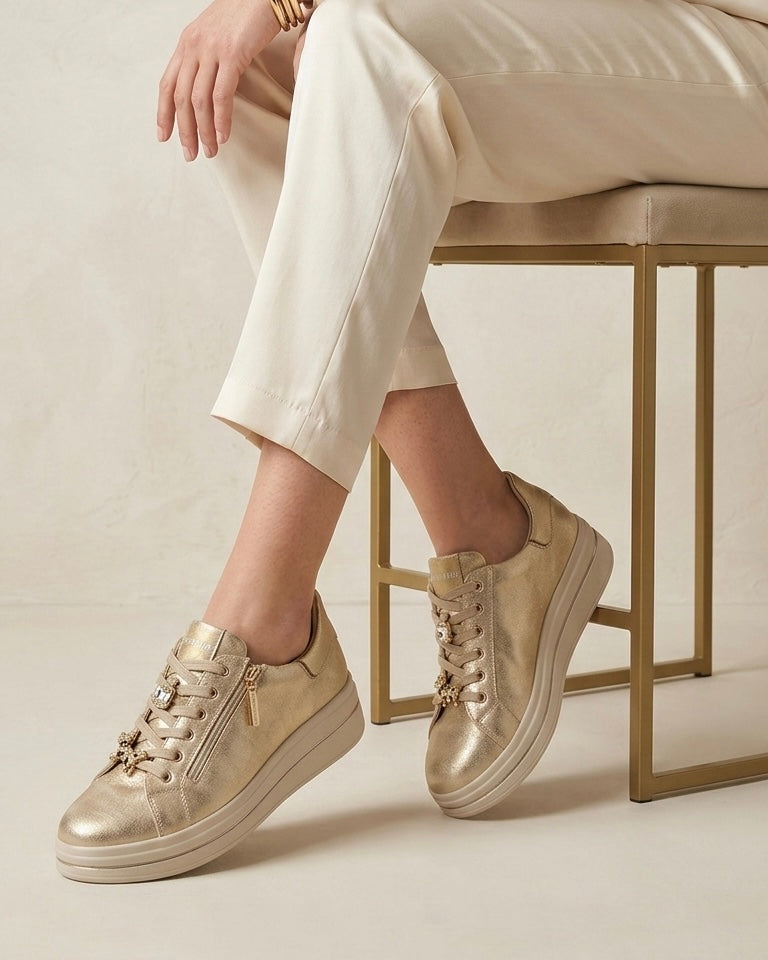 Sneakers da donna marca Valleverde color oro metallizzato, lacci in tinta con applicazioni gioiello a forma di leopardo e strass, pratica zip laterale e suola platform beige-modella.