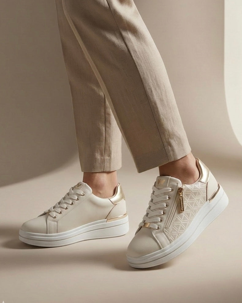 Sneakers da donna brand Valleverde color panna e bianco, con tomaia traforata al laser, inserti oro platino sul tallone e pratica zip laterale-indossate.