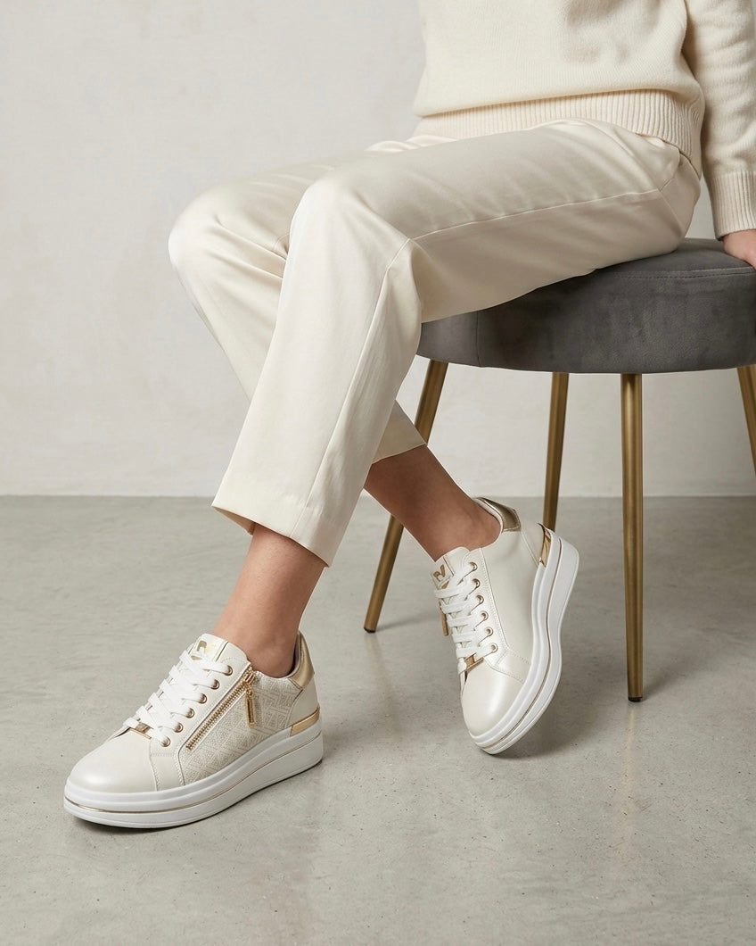 Sneakers da donna brand Valleverde color panna e bianco, con tomaia traforata al laser, inserti oro platino sul tallone e pratica zip laterale-modella.