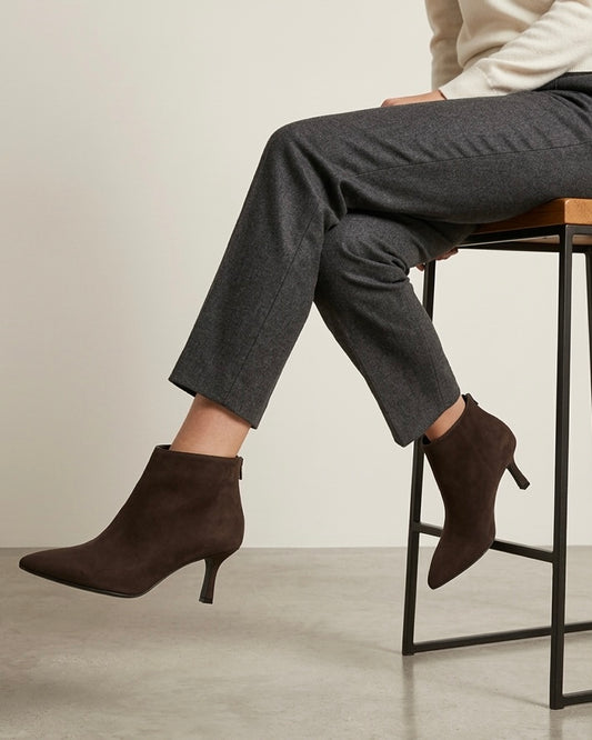 Tronchetti scamosciati marroni a punta con tacco sottile medio e design essenziale alla caviglia-modella.