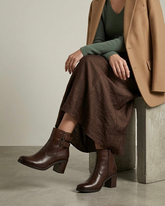 Stivaletti marrone scuro in pelle liscia con doppio cinturino laterale, fibbie metalliche brunite e tacco largo effetto legno-modella.