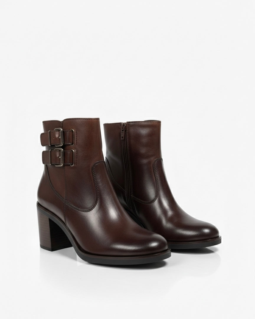 Stivaletti marrone scuro in pelle liscia con doppio cinturino laterale, fibbie metalliche brunite e tacco largo effetto legno.