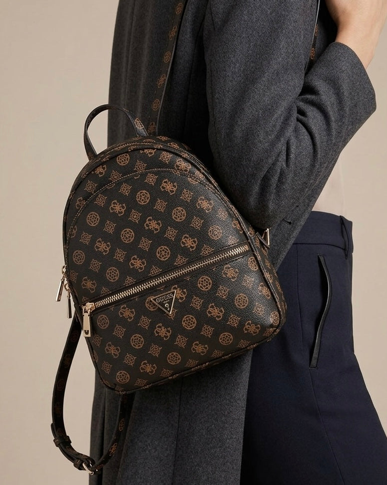 Zaino da donna brand GUESS color marrone scuro con stampa logo 4G all-over, tre tasche con zip dorate e logo a triangolo frontale-modella.