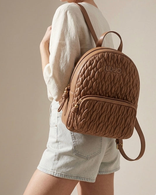 Zaino donna Liu Jo color cuoio con lavorazione trapuntata matelassé, logo lettering dorato e tasca frontale esterna-modella.