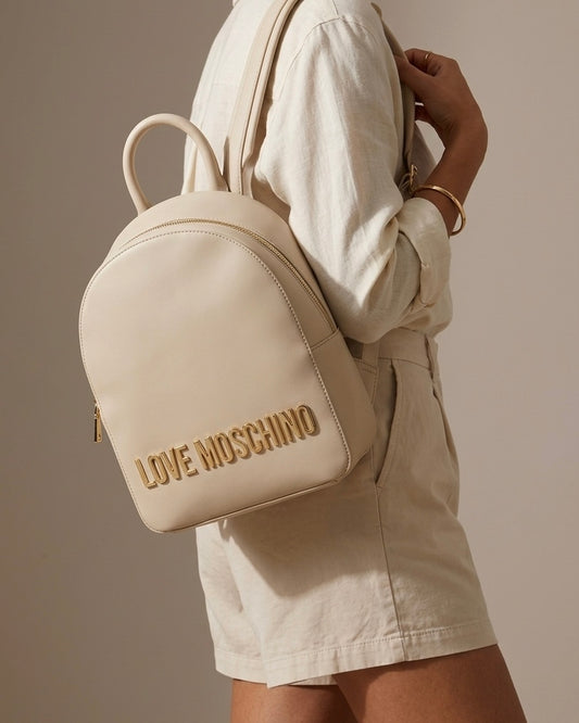 Zaino da donna Love Moschino color beige sabbia con grande scritta logo in metallo dorato frontale-modella.