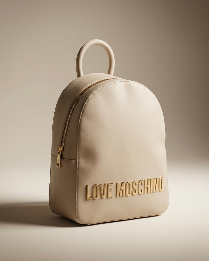 Zaino da donna Love Moschino color beige sabbia con grande scritta logo in metallo dorato frontale.